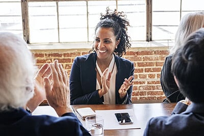 business woman at meeting clapping